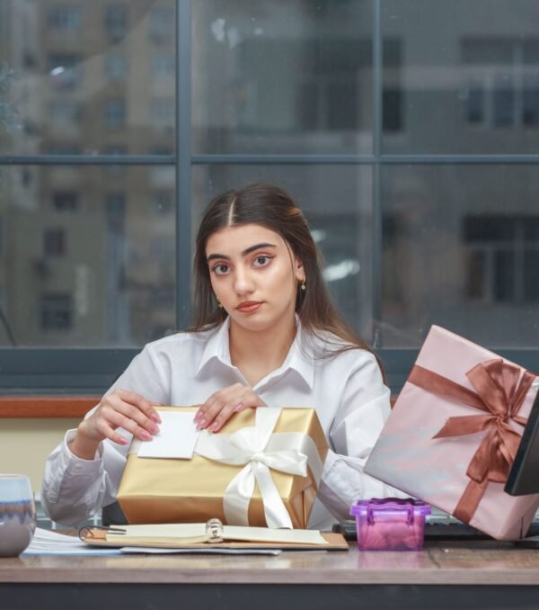 young-girl-sitting-desk-trying-open-her-gift-box-2